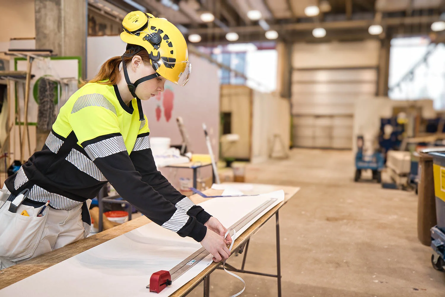 En ung ytbehandlare arbetar i en bygghall